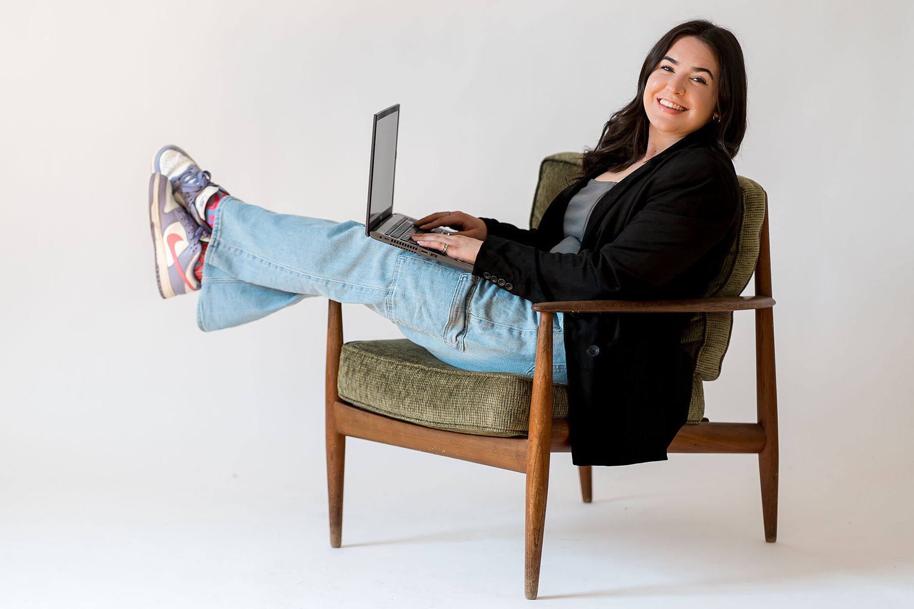 Maggie Armstrong, lifestyle and habits coach, sitting with a laptop and smiling during a coaching session.